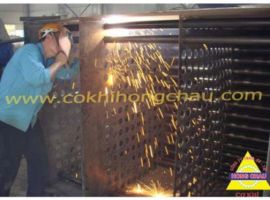 Workers are performing pipe welding in the boiler system